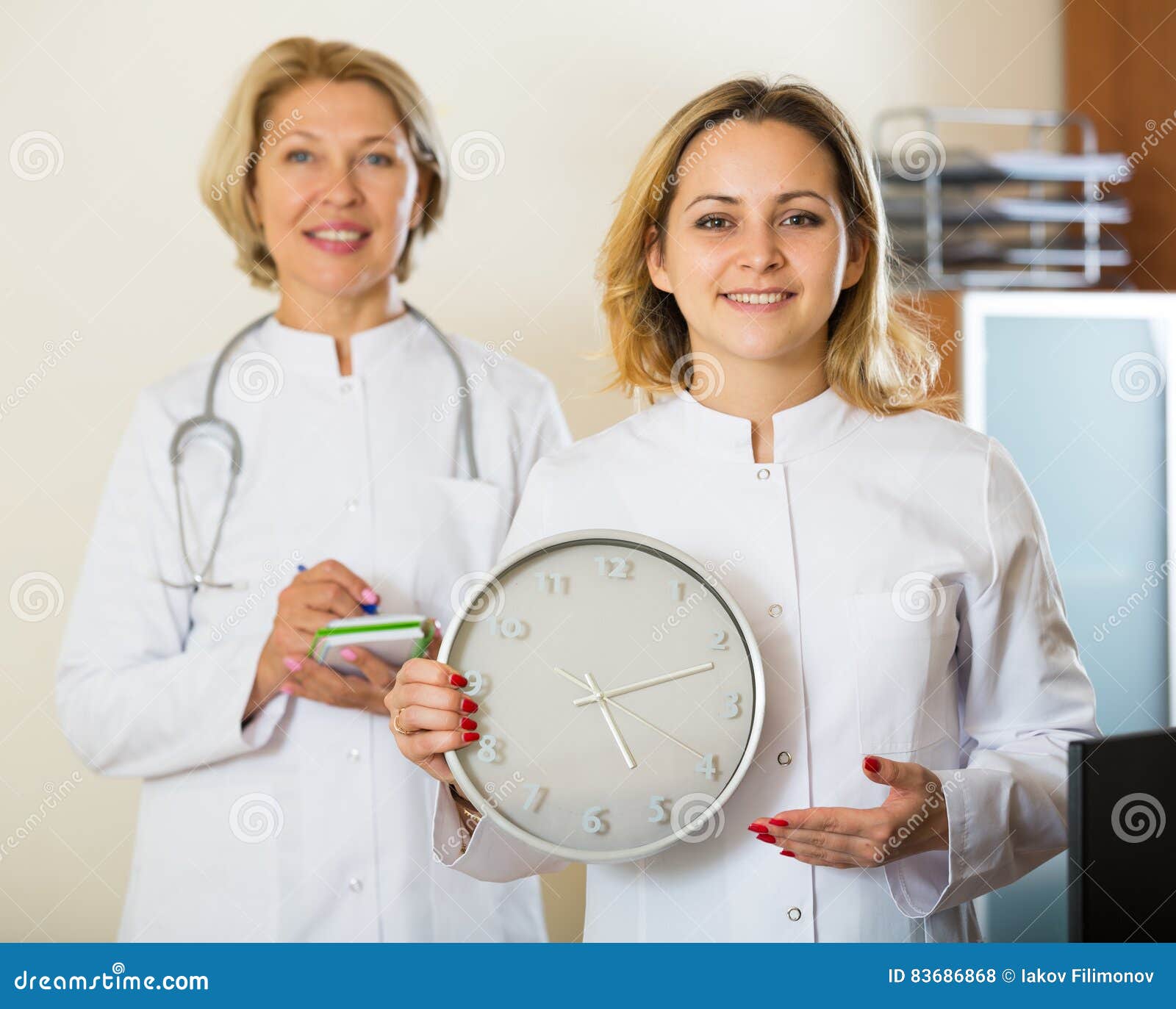 Two Female Doctors Showing Time in Clock Stock Photo Image of medicine, health 83686868