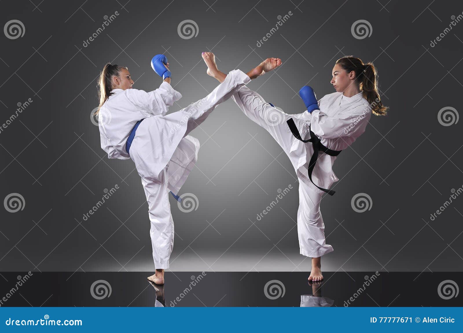 Two Female Young Karate Fighting on the Gray Background Stock Image