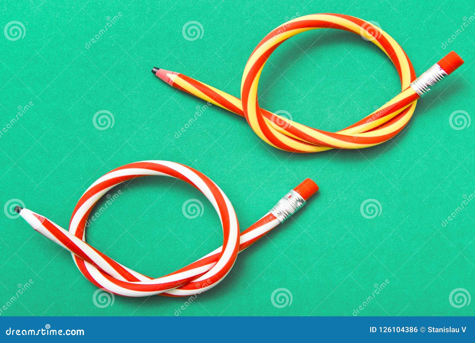 Flexible pencil on a textured cardboard background. Bent pencils two-color  Stock Photo