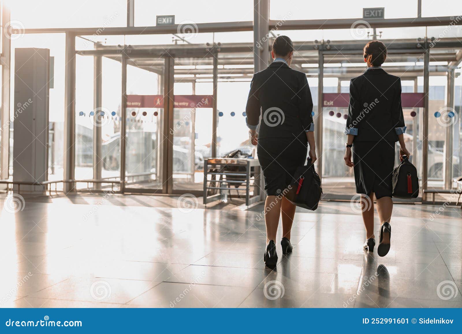 Two Flight Attendants Holding Bags and Walking in the Airport Stock Image Image of