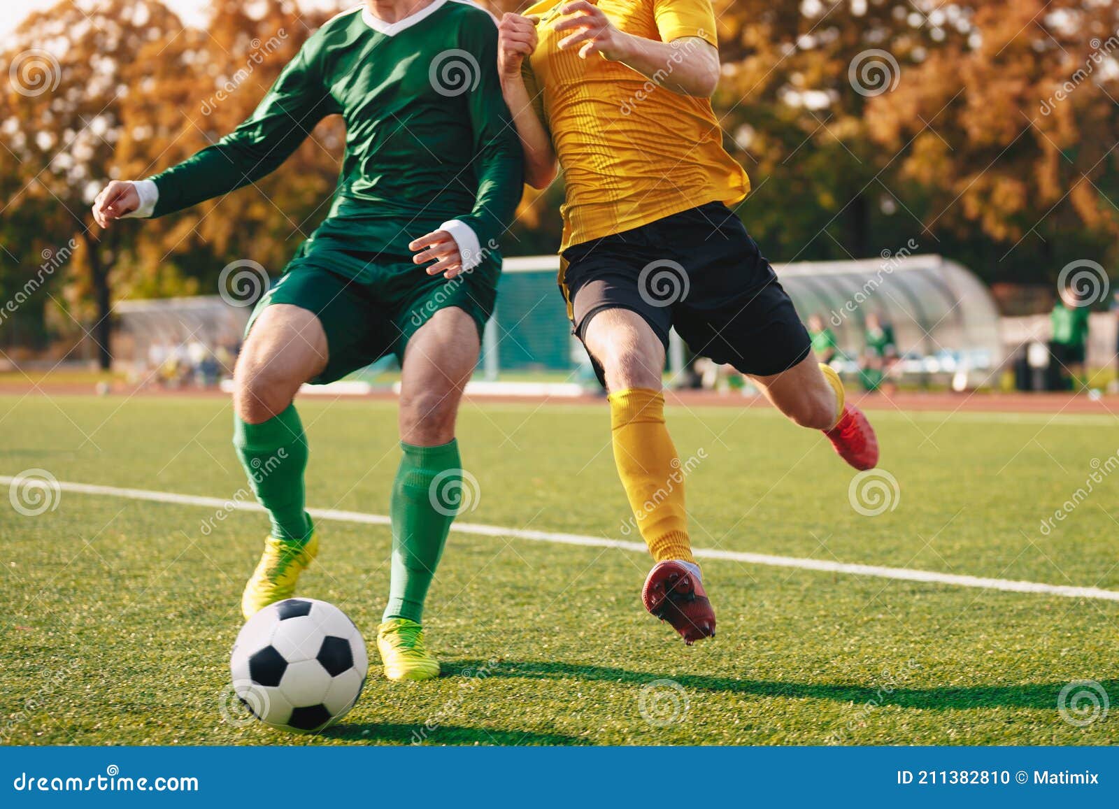 two footballers running and kicking game. adult football players compete in soccer match