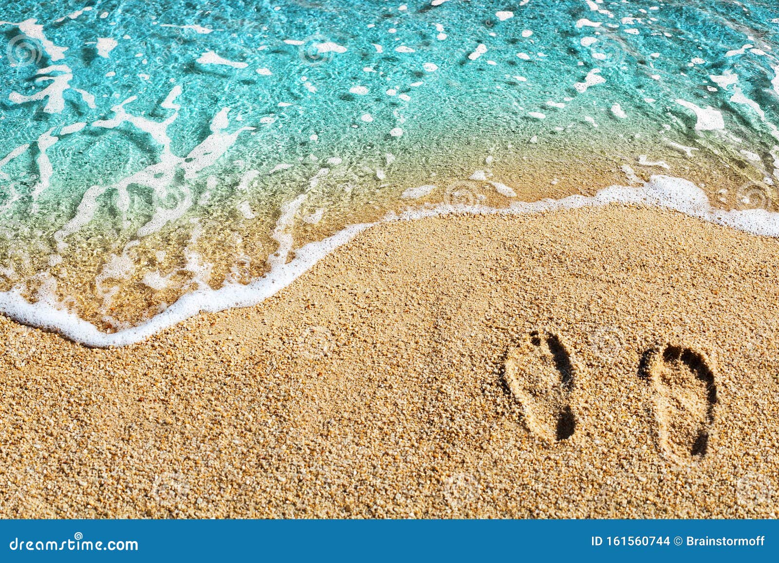 two footprints on yellow sand, blue sea wave, white foam top view close up, turquoise ocean water, summer vacations concept