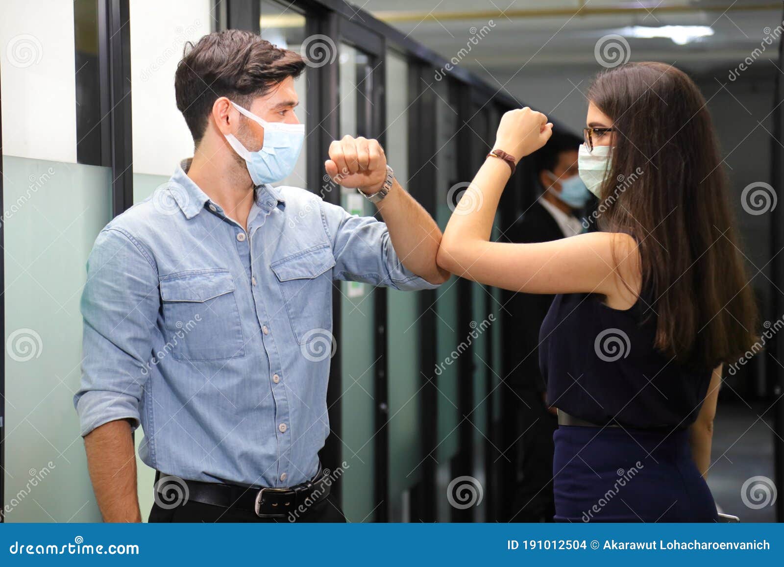 two friend meet and greet each other by using elbow bump while wearing medical face mask to help flatten the curve