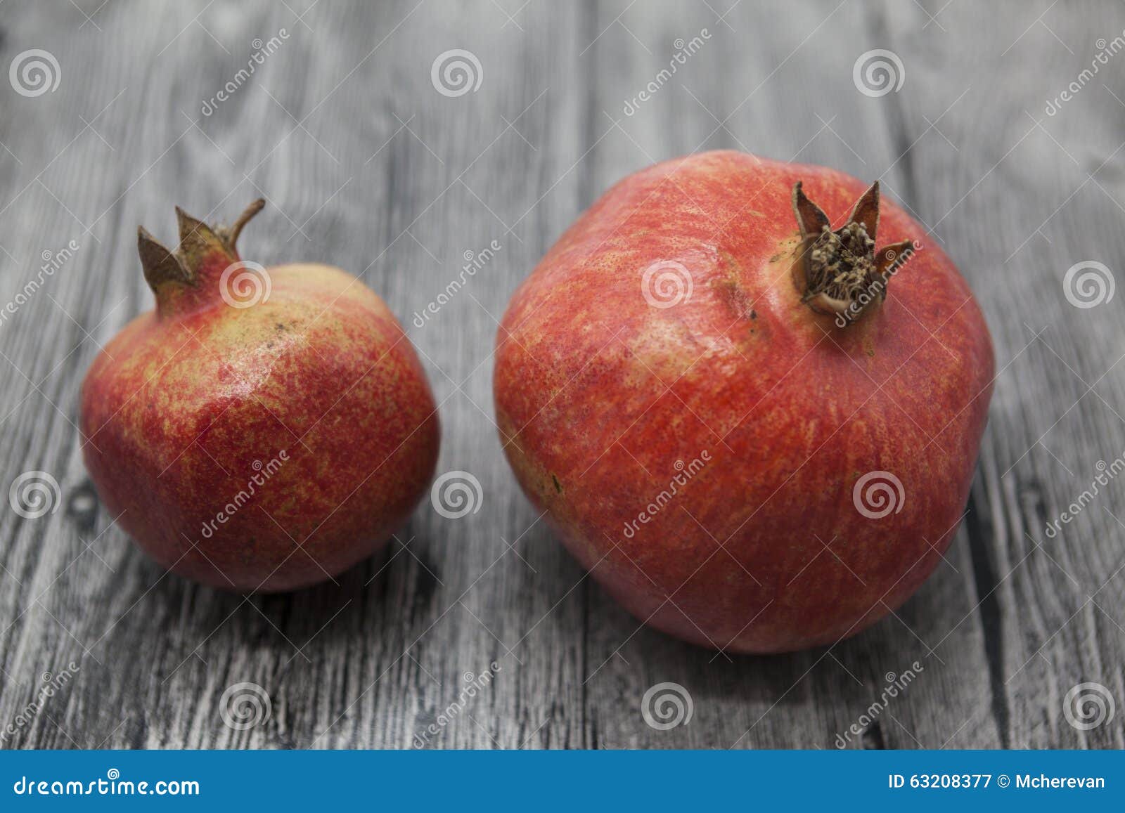 Two Fruit Juicy Spanish Pomegranate on the Wooden Background Stock