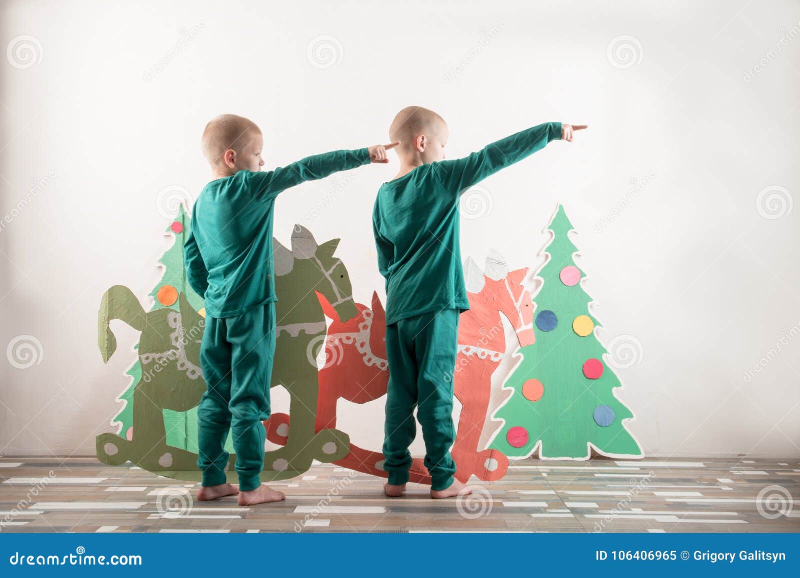 Download Two Funny Boys In A Santa Claus Hat Are Playing With Horses Drawn Cardboard