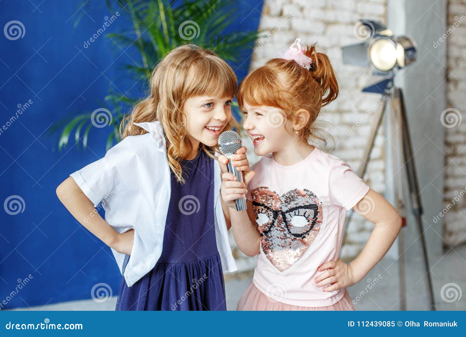 two funny children sing a song in karaoke. the concept is childh