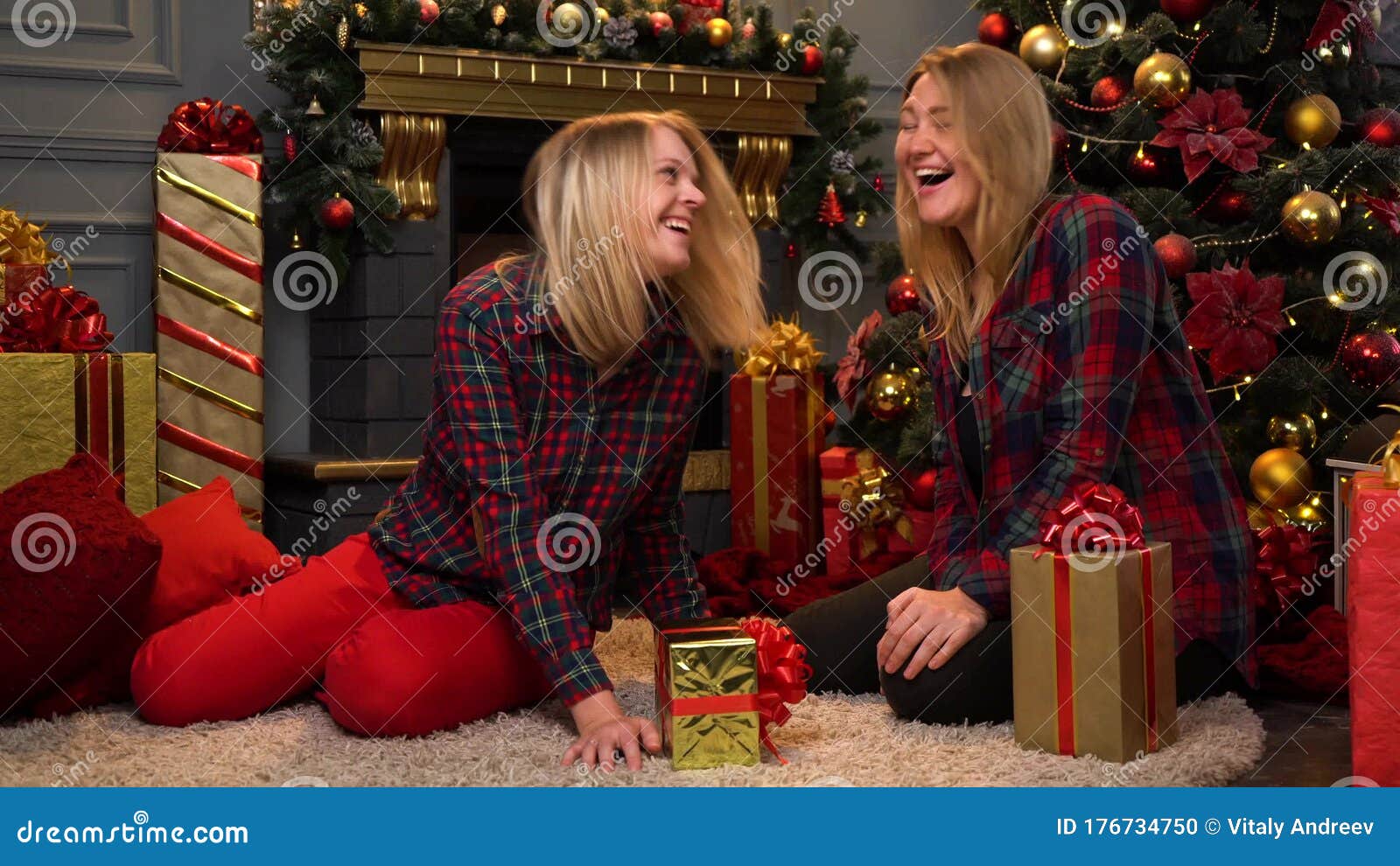 Two Funny Young Girls in Red Shirts and Funny Hats Sit Near a New Year ...