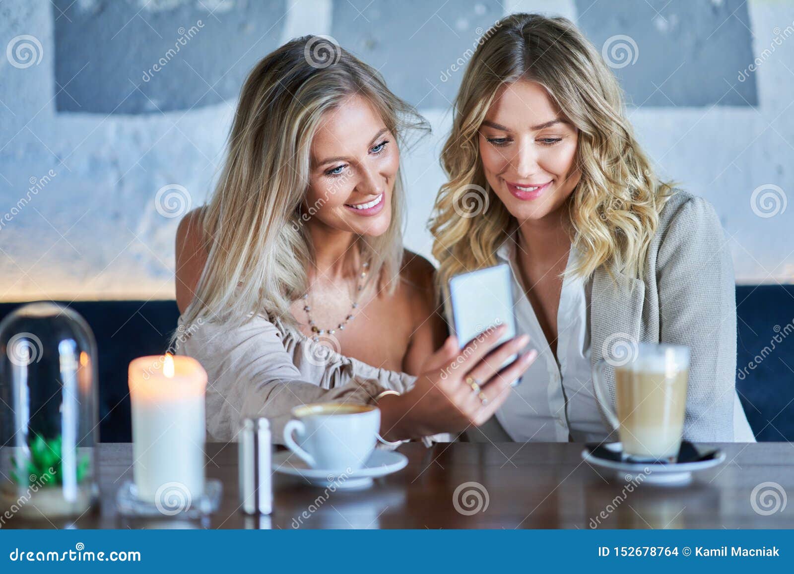 Two Girl Friends Eating Lunch in Restaurant and Using Smartphone Stock ...