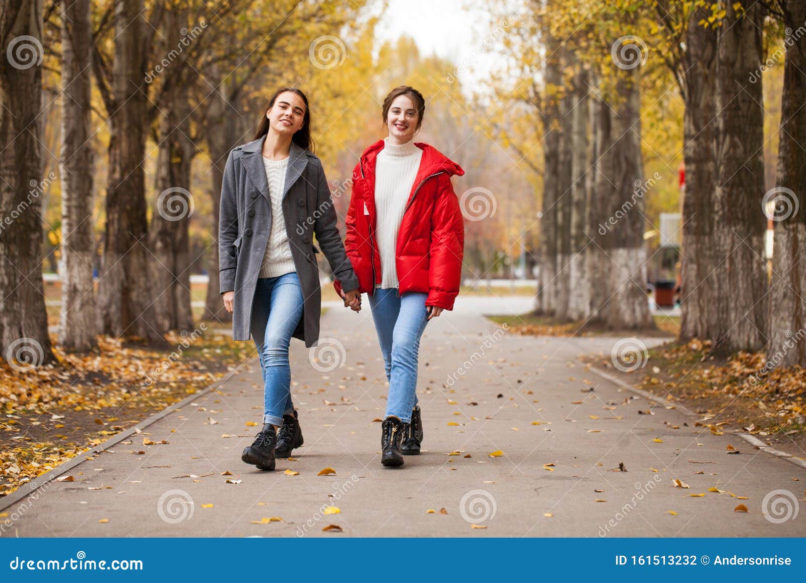 Two Girlfriends in a Gray Wool Coat and a Red Down Jacket Stock Photo