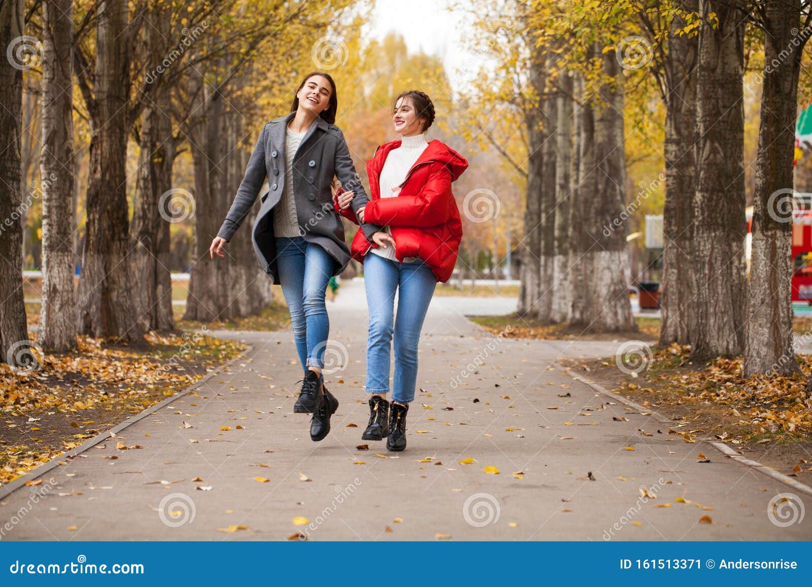 Two Girlfriends in a Gray Wool Coat and a Red Down Jacket Stock Image
