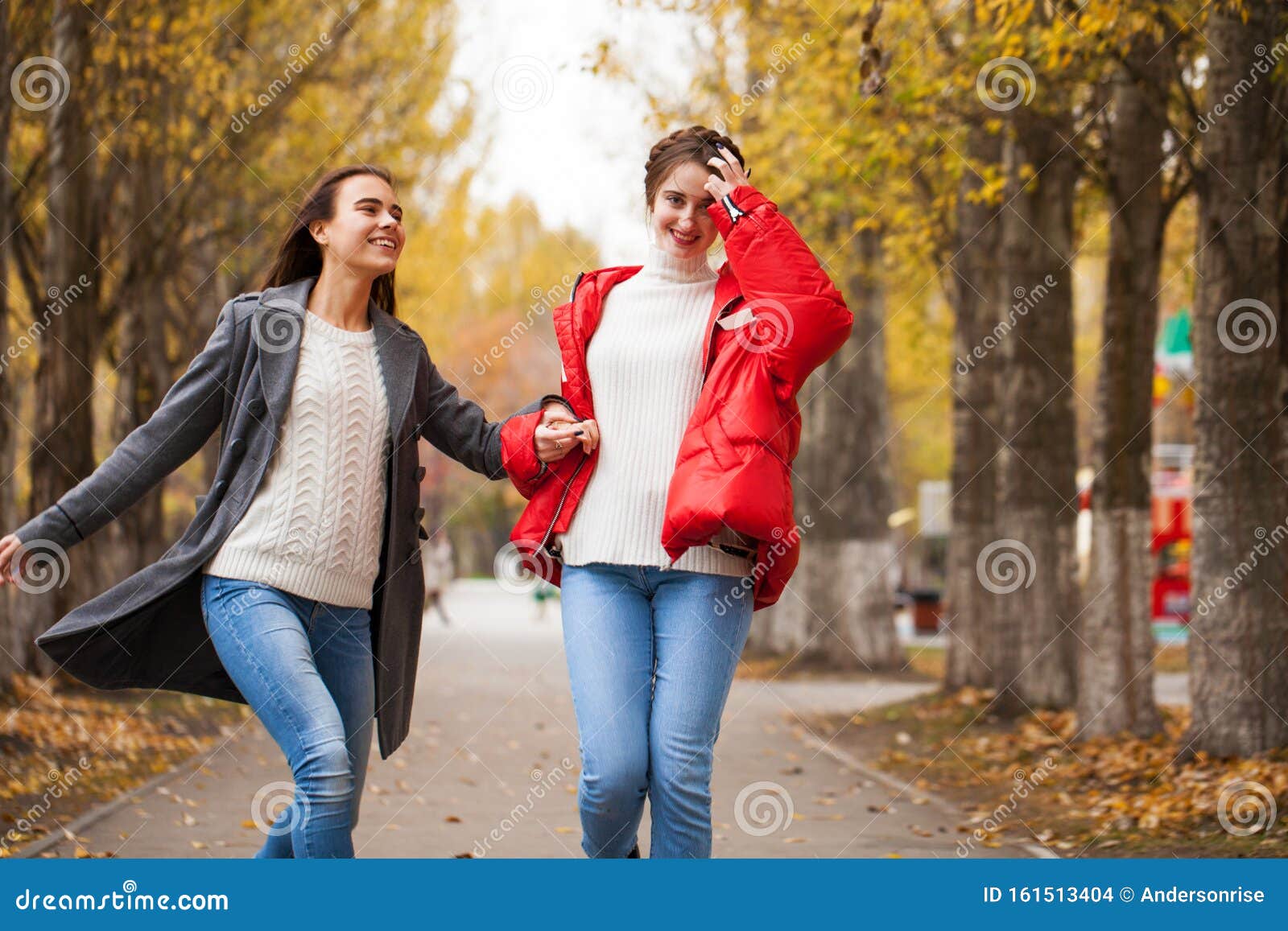 Two Girlfriends in a Gray Wool Coat and a Red Down Jacket Stock Photo