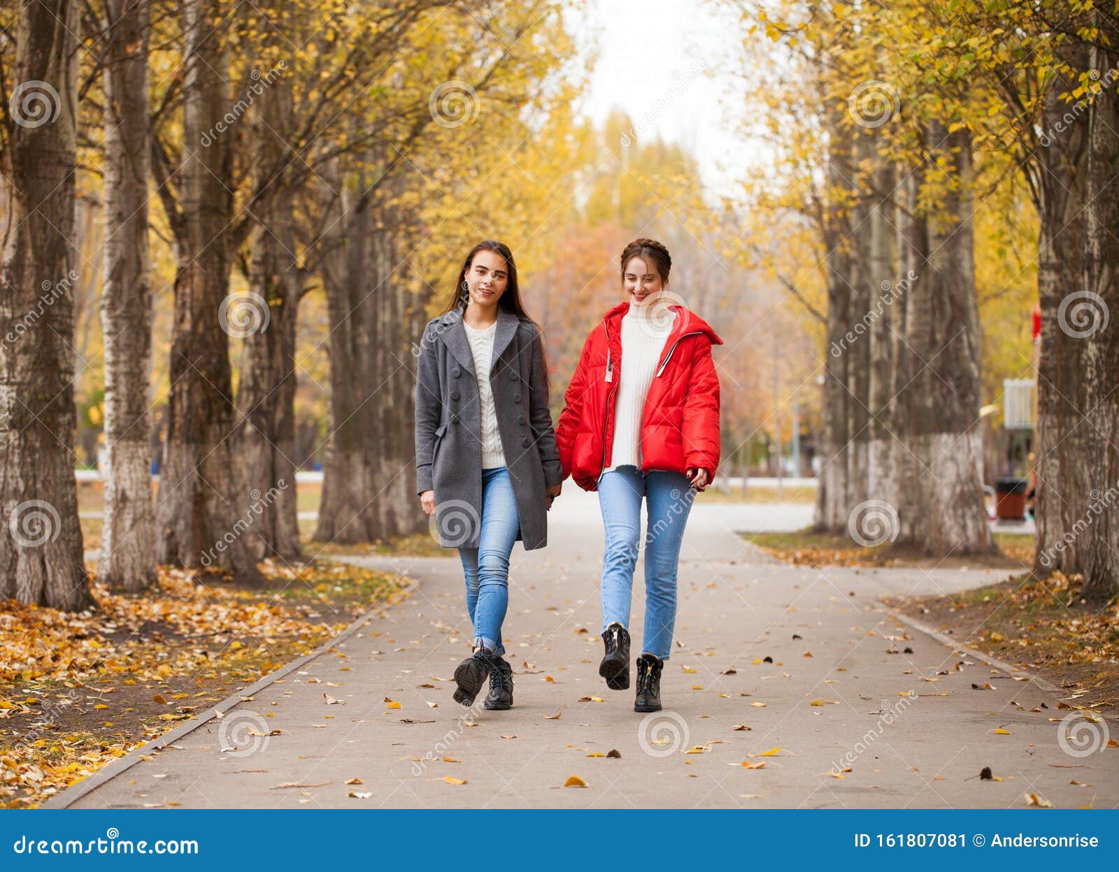 Two Girlfriends in a Gray Wool Coat and a Red Down Jacket Stock Image