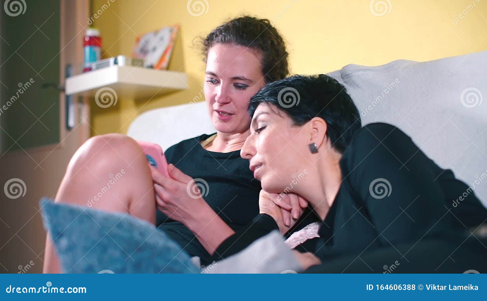 Two Girlfriends are Sitting on the Couch before a Party at Home