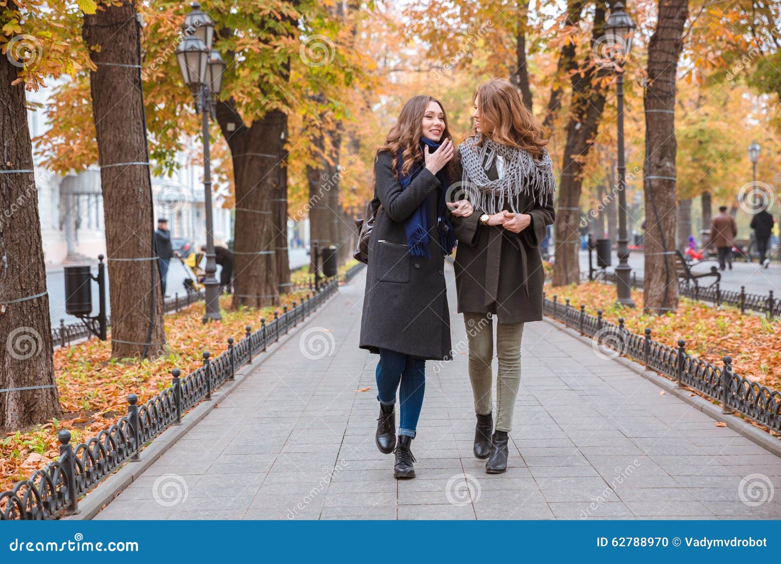 Two Girlfriends Walking and Talking Outdoors Stock Photo - Image of ...