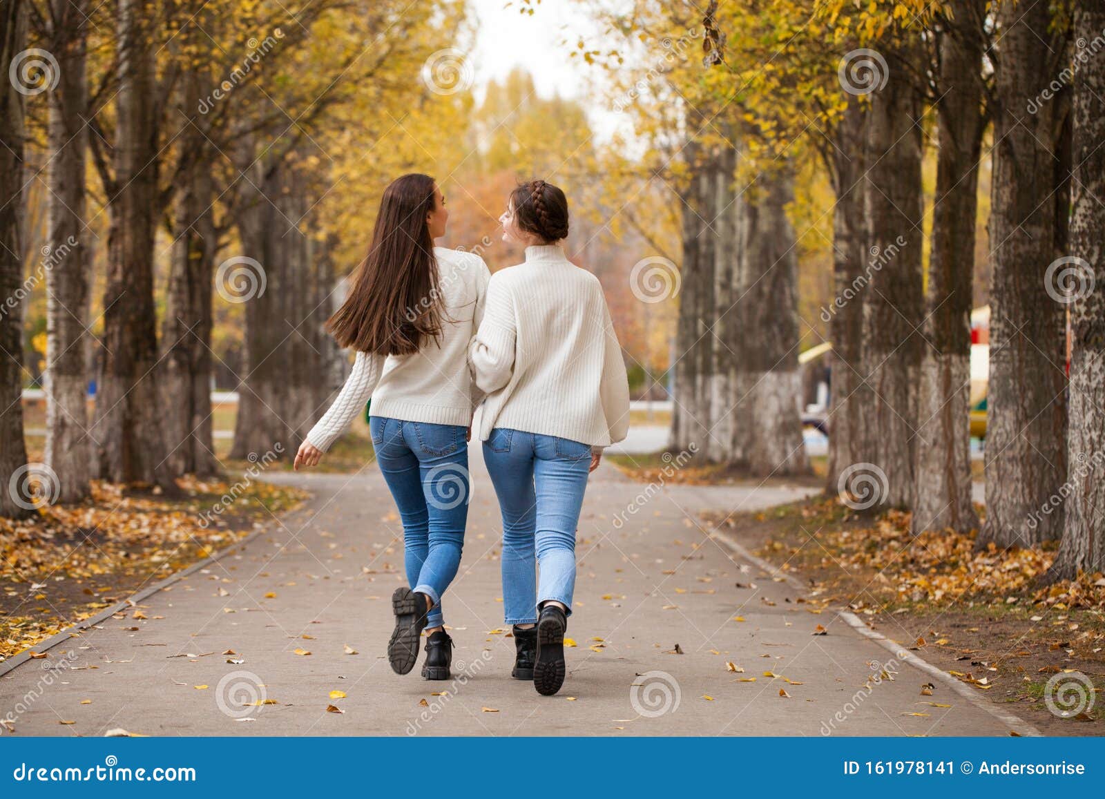 Two Girlfriends in a White Woolen Sweater and Blue Jeans Stock Image ...
