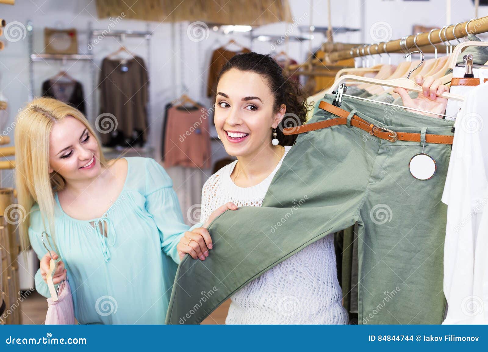 Two girls choosing clothes stock photo. Image of people - 84844744