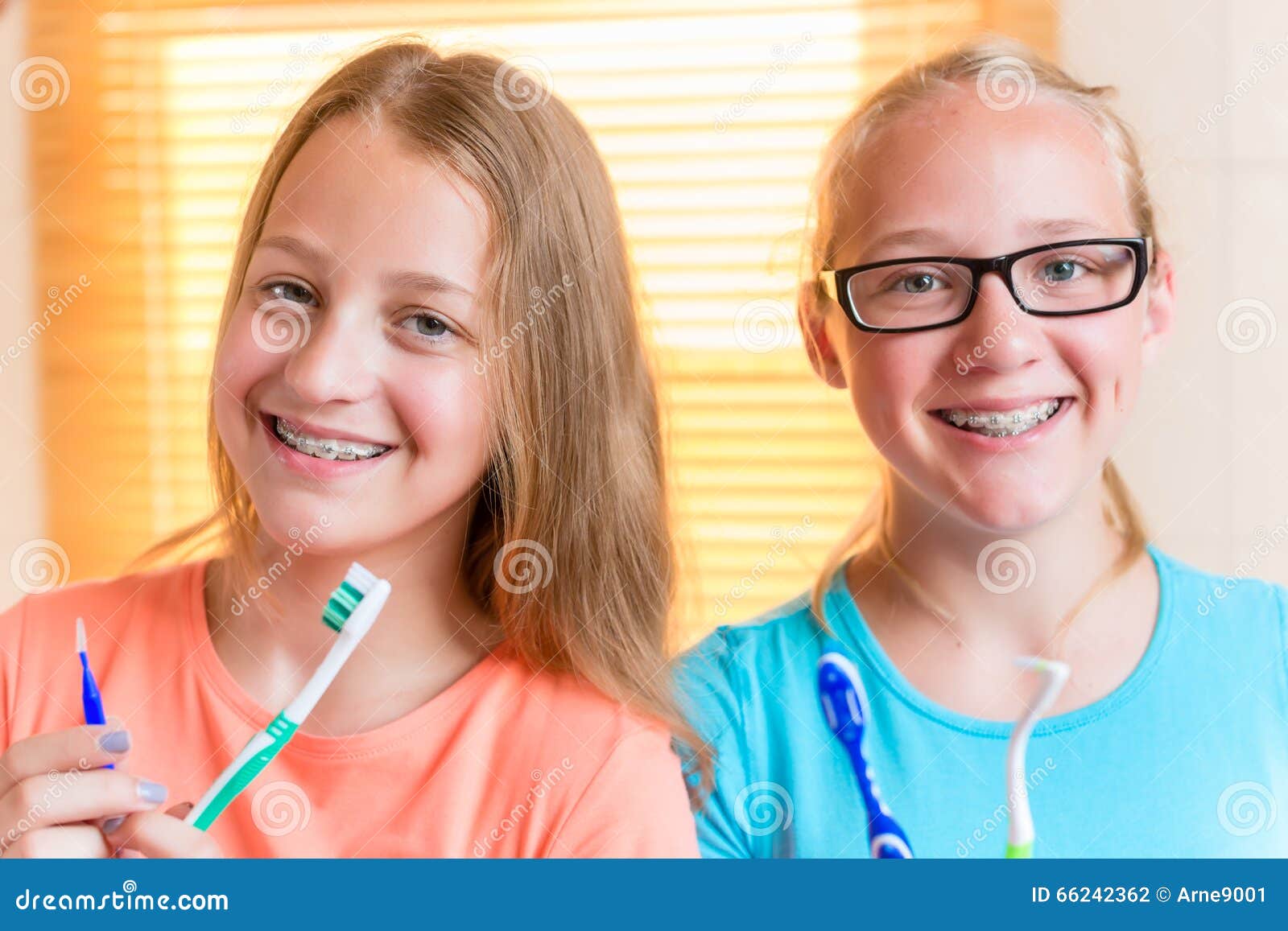 Two Girls With Dental Retainers Brushing Teeth RoyaltyFree Stock Image