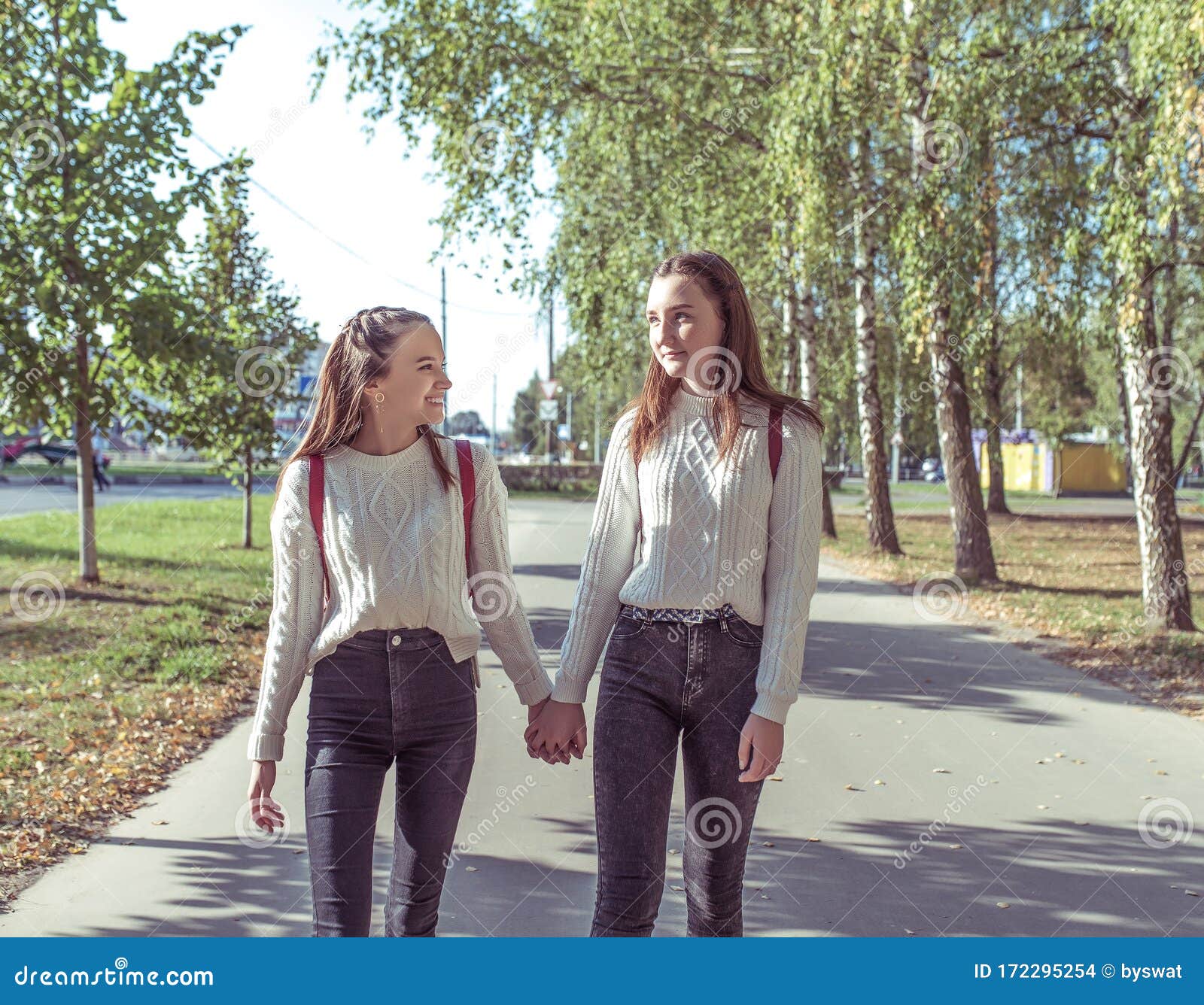 Two Girls Girlfriends Schoolgirls 12 14 Years Old Walk In Summer Park Background Road Trees 