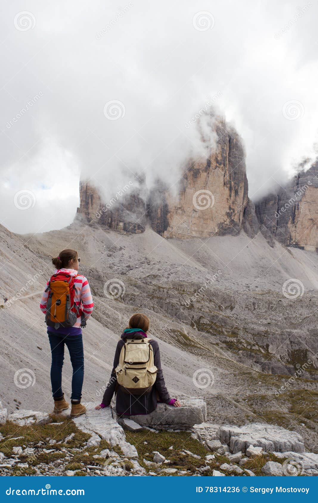 Two girls hikers looking at the rocks. Two girls hikers resting and looking at the rocks