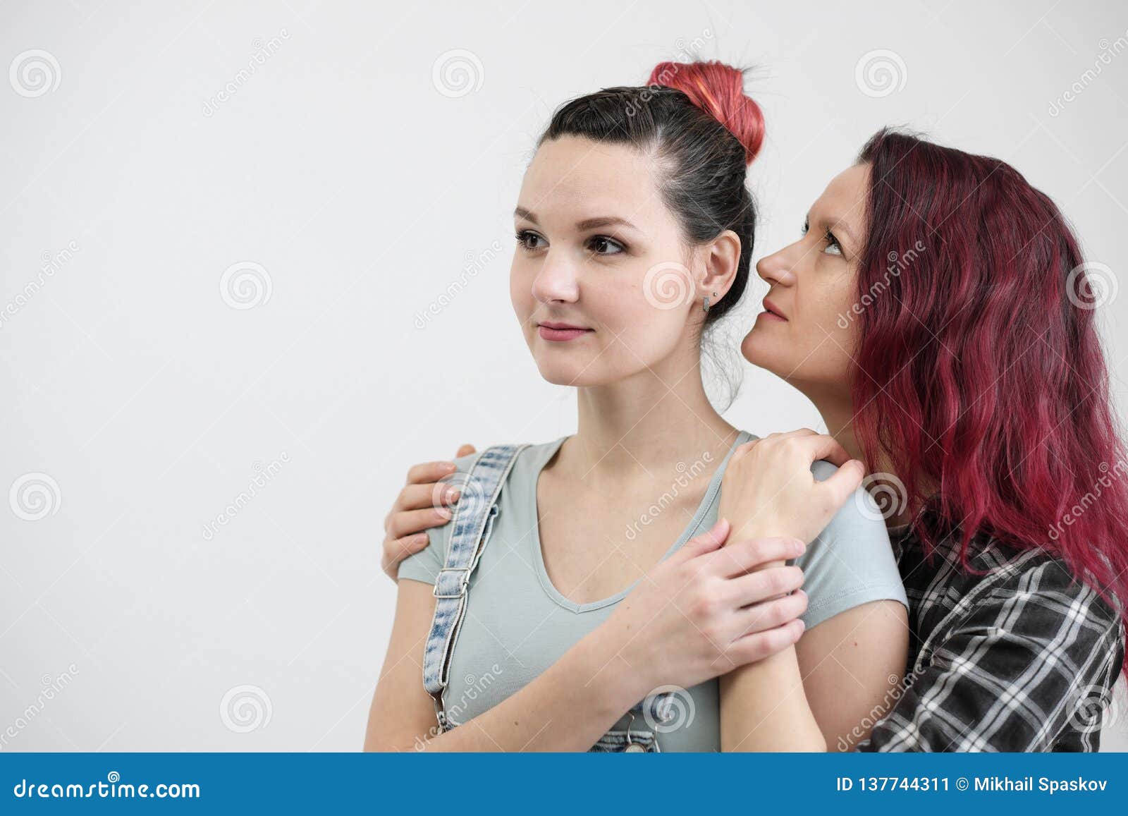 Two Girls Hug on a White Background