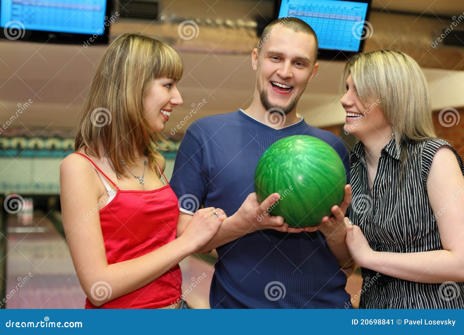 two girls and man stand alongside and laugh