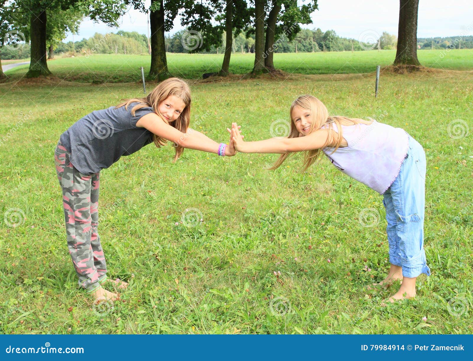 https://thumbs.dreamstime.com/z/two-girls-playing-exercising-yoga-meadow-little-barefoot-kids-standing-half-forward-bend-touching-palms-hands-green-79984914.jpg