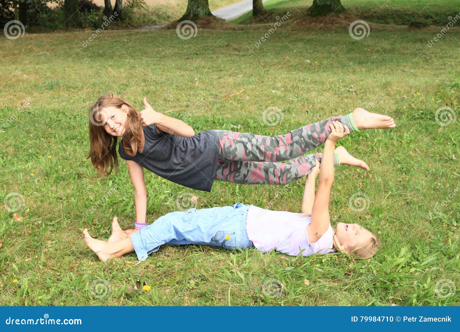 https://thumbs.dreamstime.com/z/two-girls-playing-exercising-yoga-meadow-little-barefoot-kids-supported-exercises-one-above-another-thumb-up-79984710.jpg