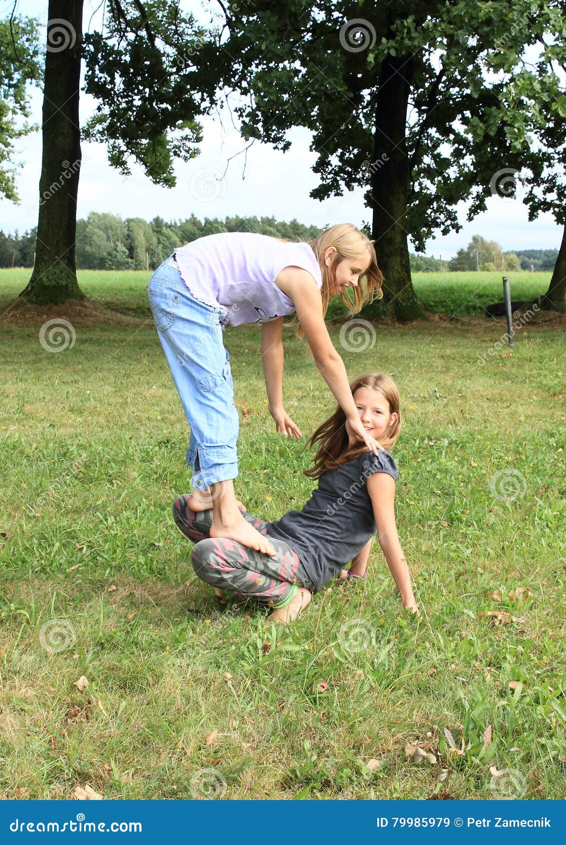 https://thumbs.dreamstime.com/z/two-girls-playing-standing-each-other-little-smiling-barefoot-kids-exercising-one-thighs-one-green-grass-79985979.jpg