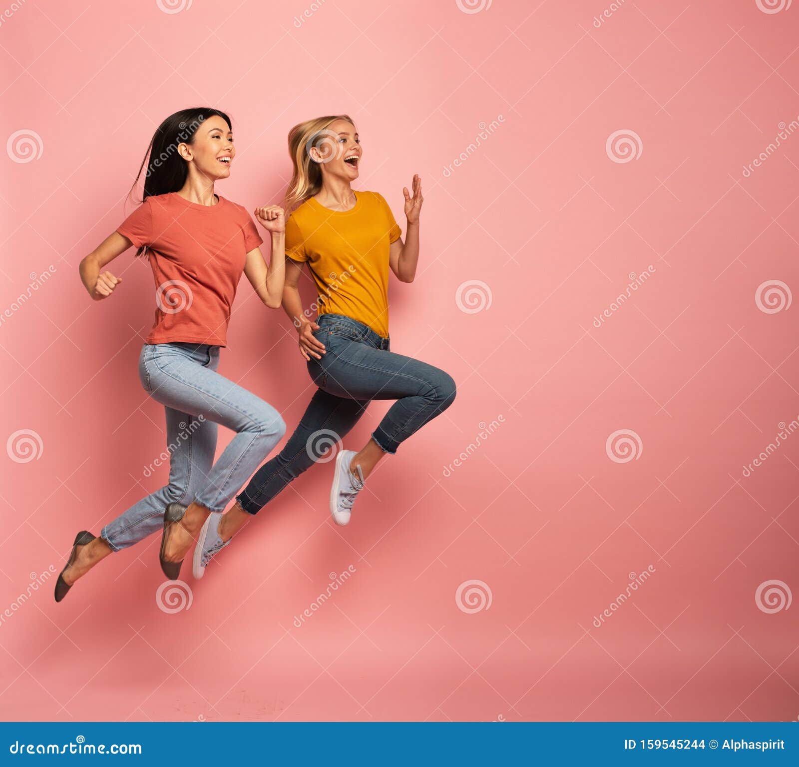 two girls run fast. concept of energy and vitality. pink background