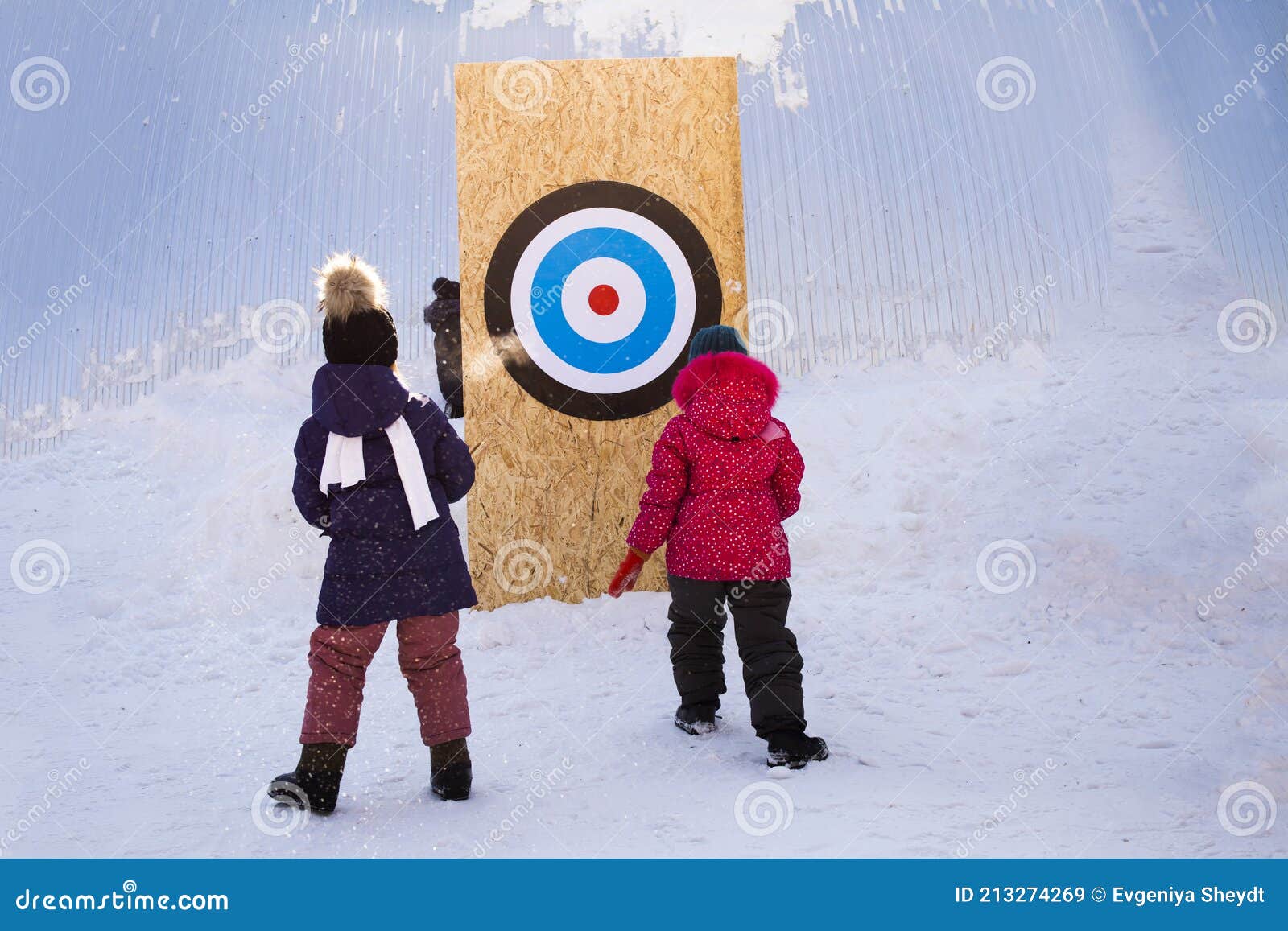 Two Girls Throw Snowballs at a Target in Winter on a Sunny Day, Outdoor Fun Games, Kids Competition Editorial Stock Image