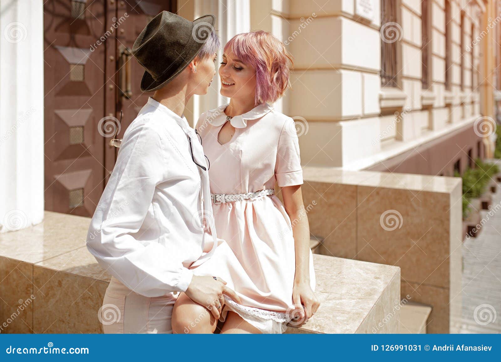 Two Girls Touching Each Other Near The Stairs Of The Building In The 