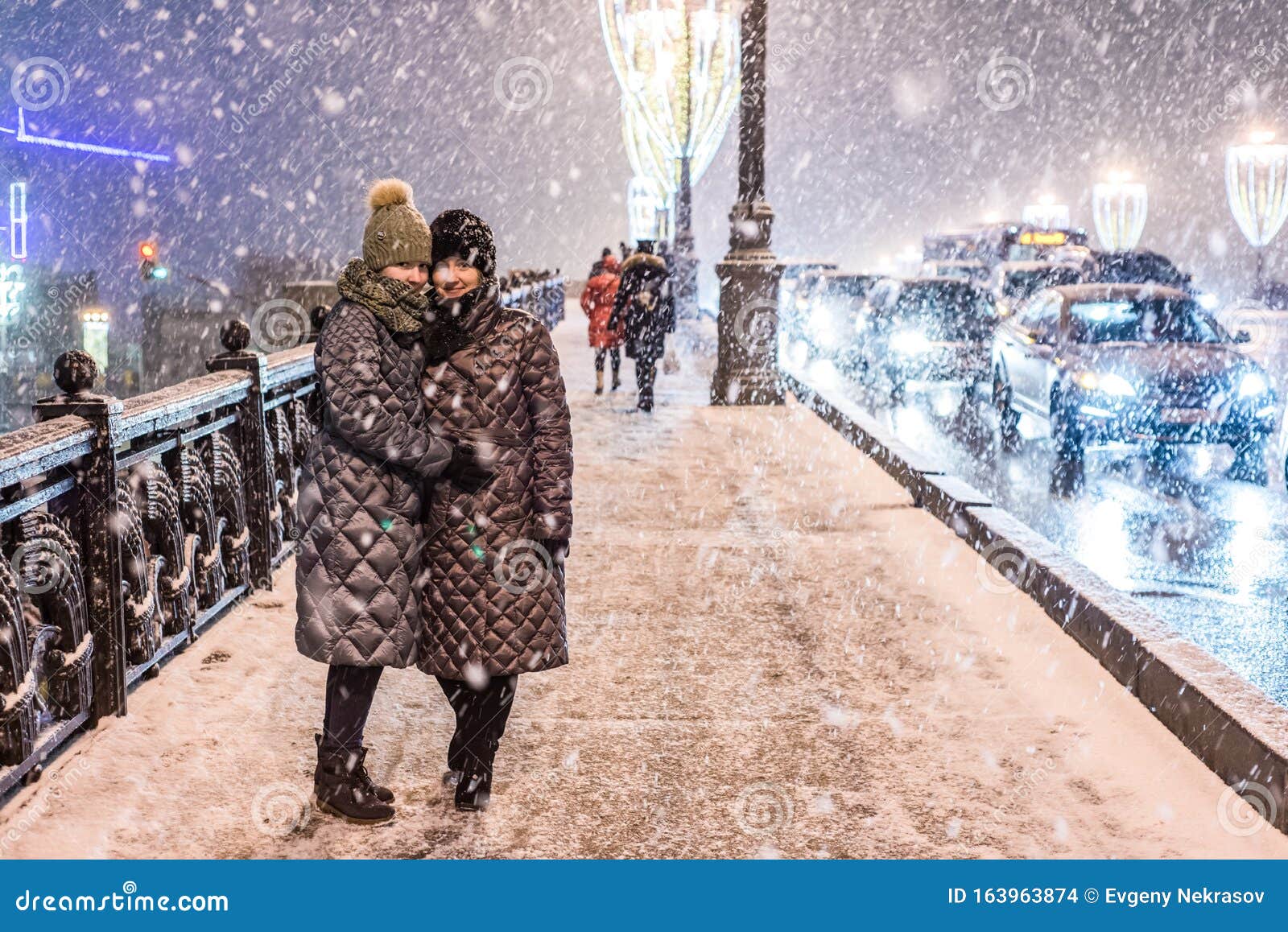 Two Girls in Warm Winter Clothes in Heavy Snow are Standing on the