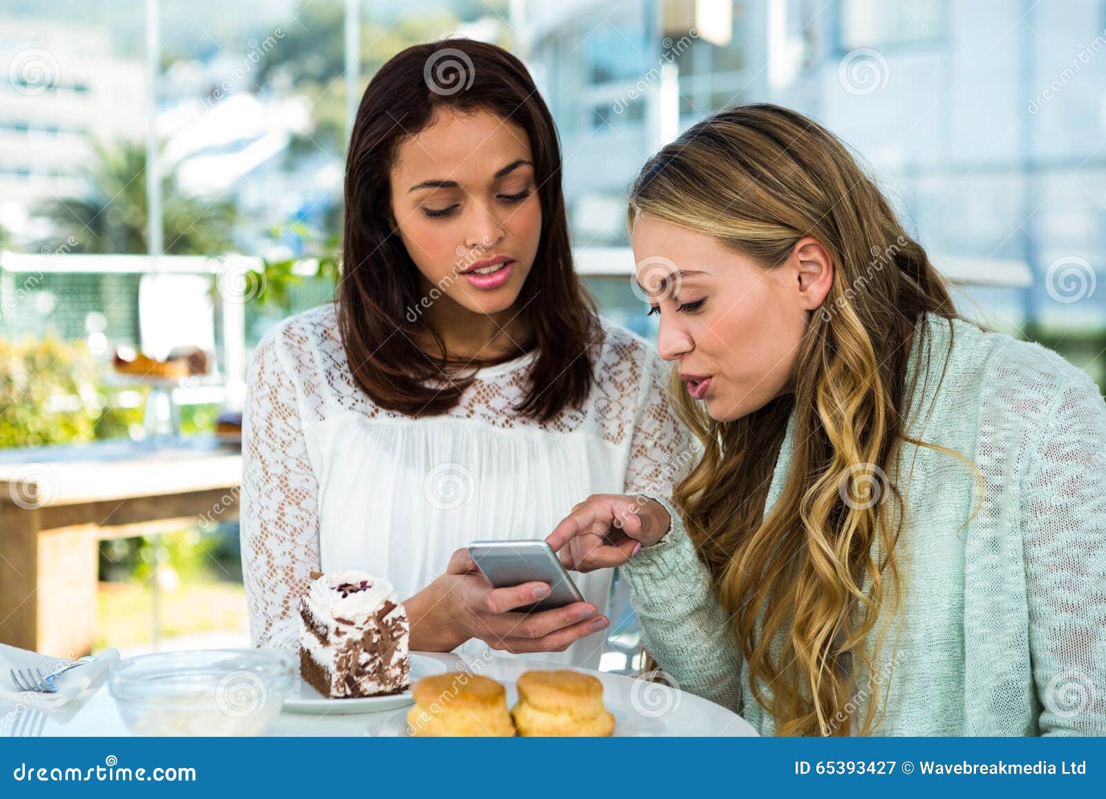 Two girls watch a phone stock image. Image of friendliness - 65393427