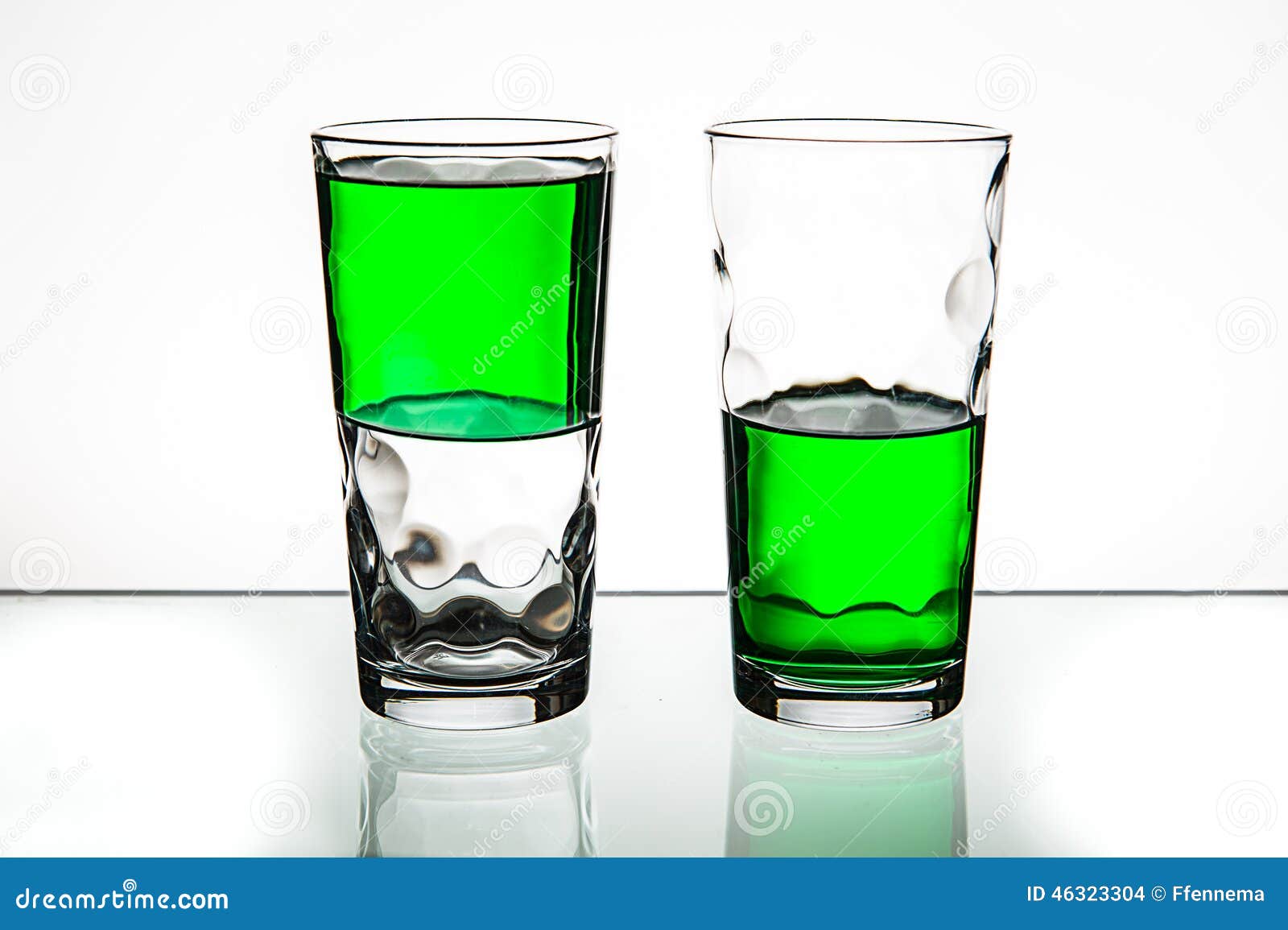 Two Glasses, Both Halffull of Green Liquid. Stock Photo Image of