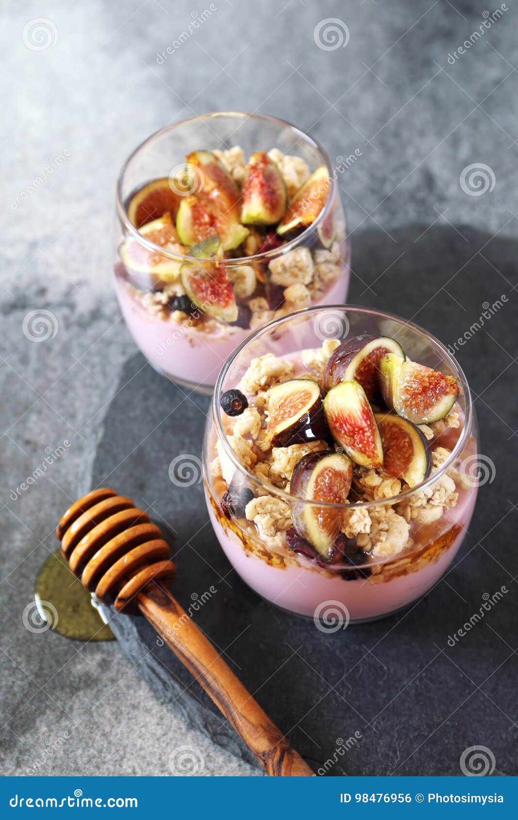 Two Glasses of Fruit Yogurt with Granola, Figs and Honey Stock Photo