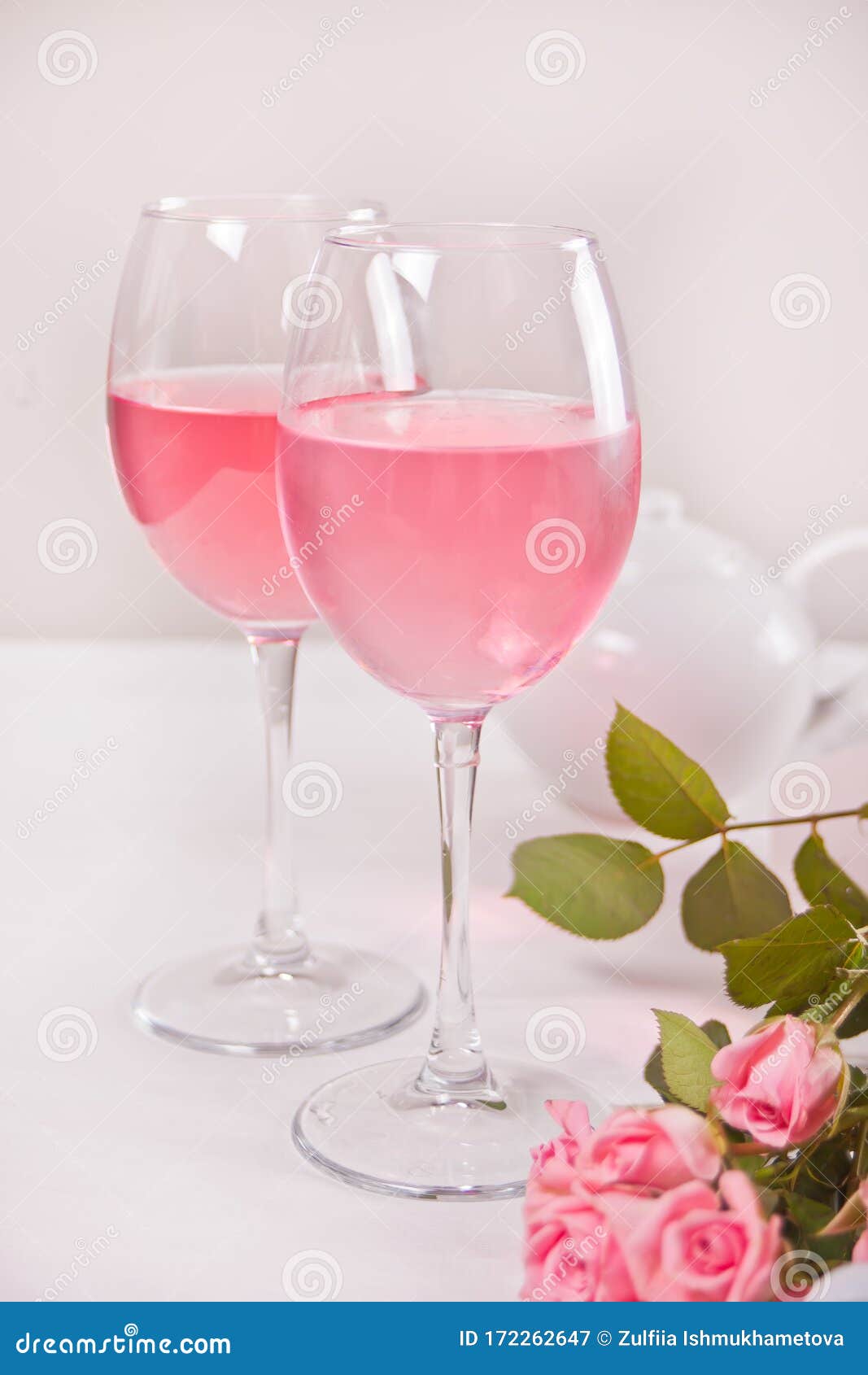 Two Glasses with Pink Grape Wine with Rose Flowers. Romantic Dinner