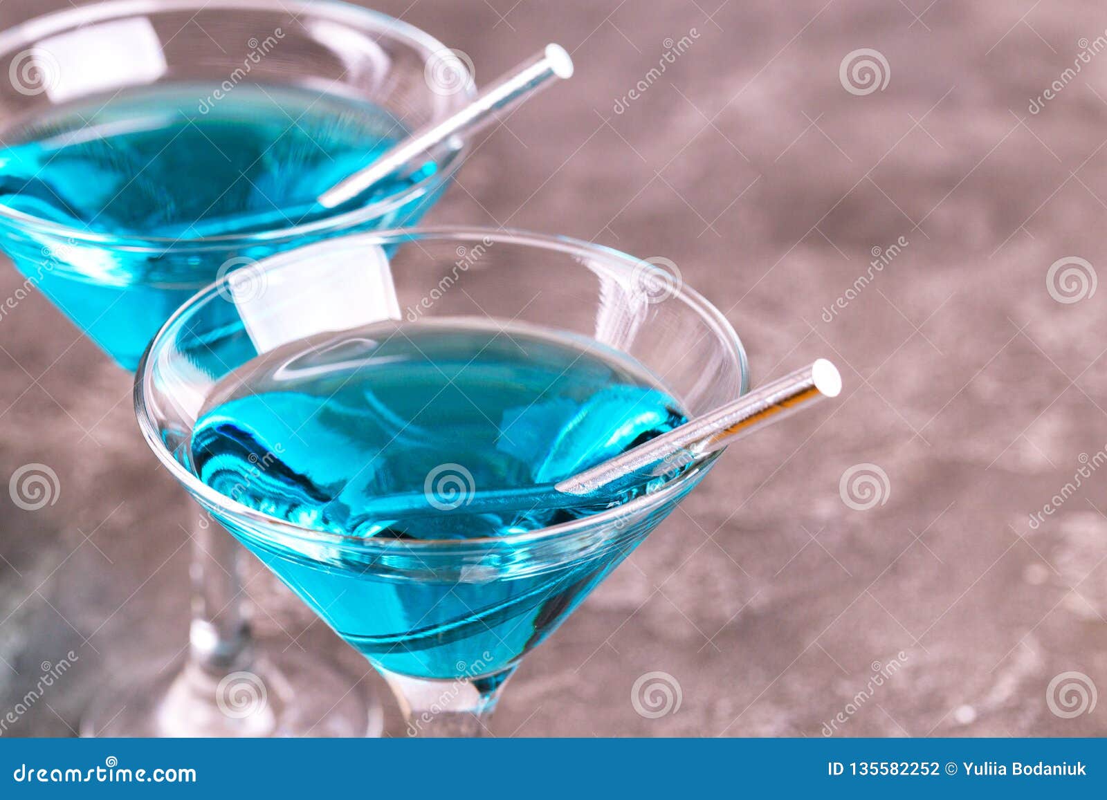 two glasses of trendy blue wine with paper straws