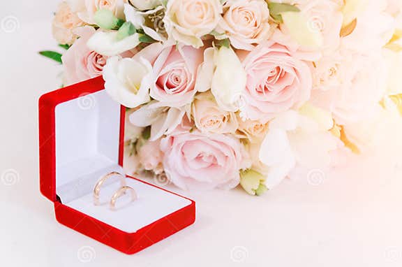 Two Gold Rings in Red Box Near Beautiful Creame Roses on White ...