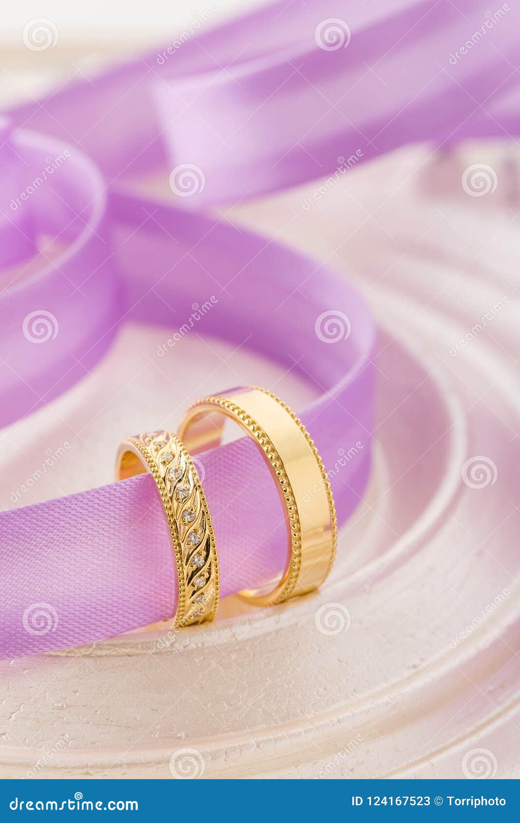 Two Gold Wedding Rings On Purple Ribbon Background Stock