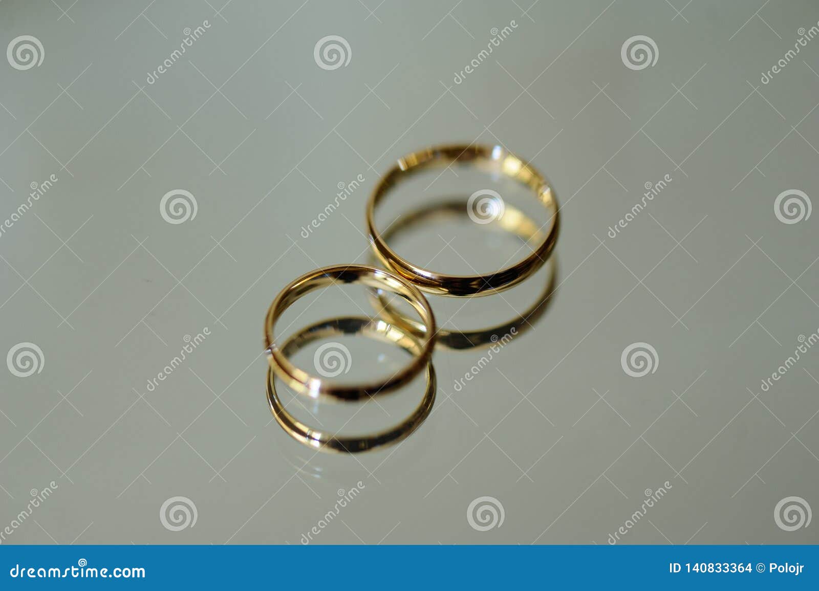 two golden wedding rings with reflection