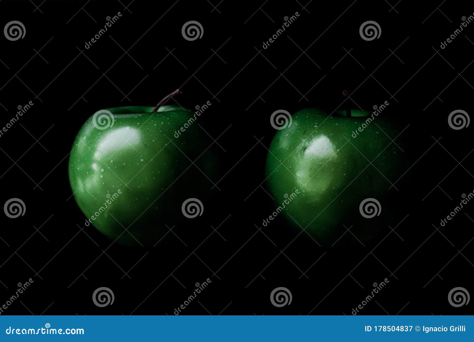 two green apples on black background