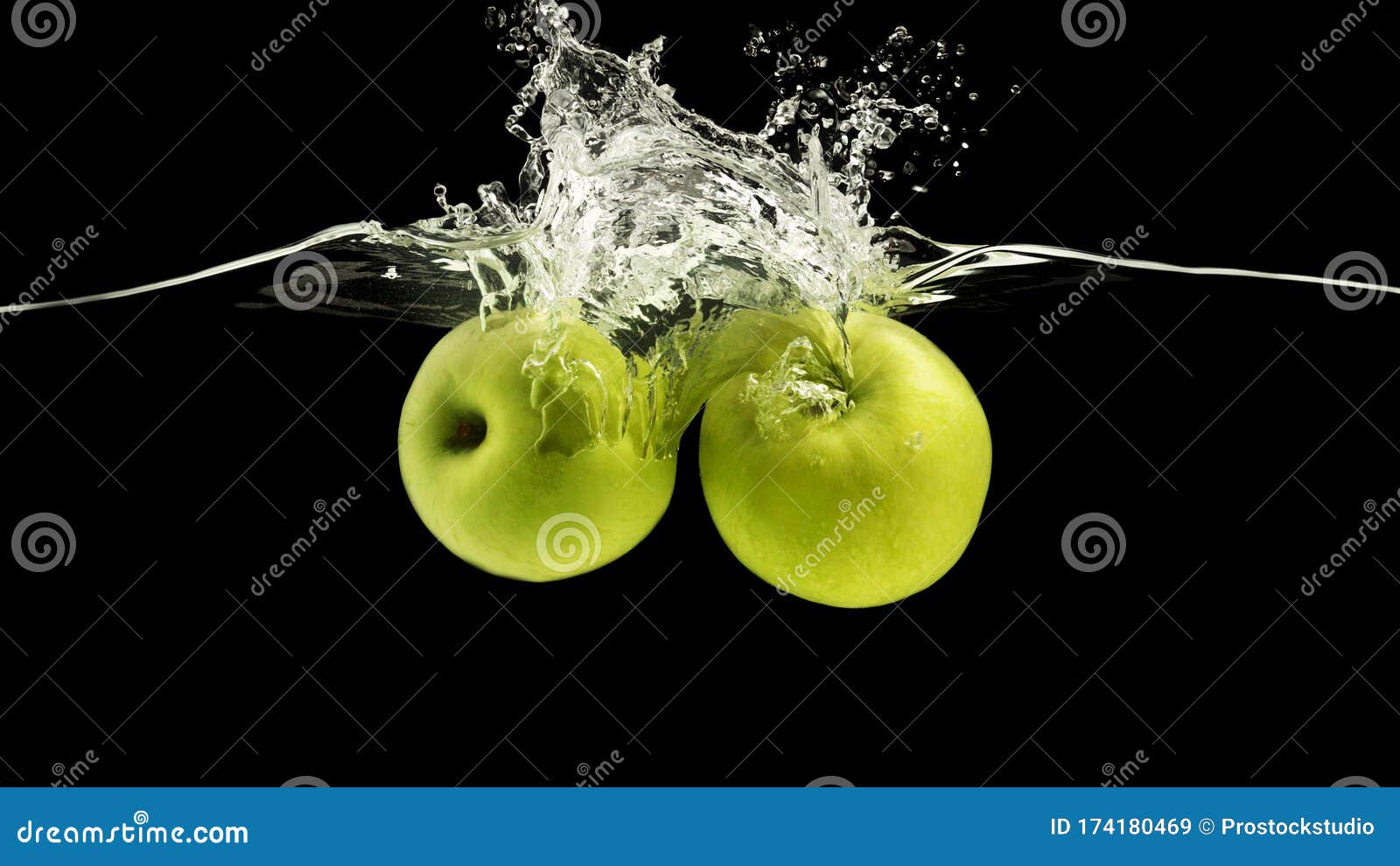 Two Green Apples Splattering into Water with Waves on Black Background
