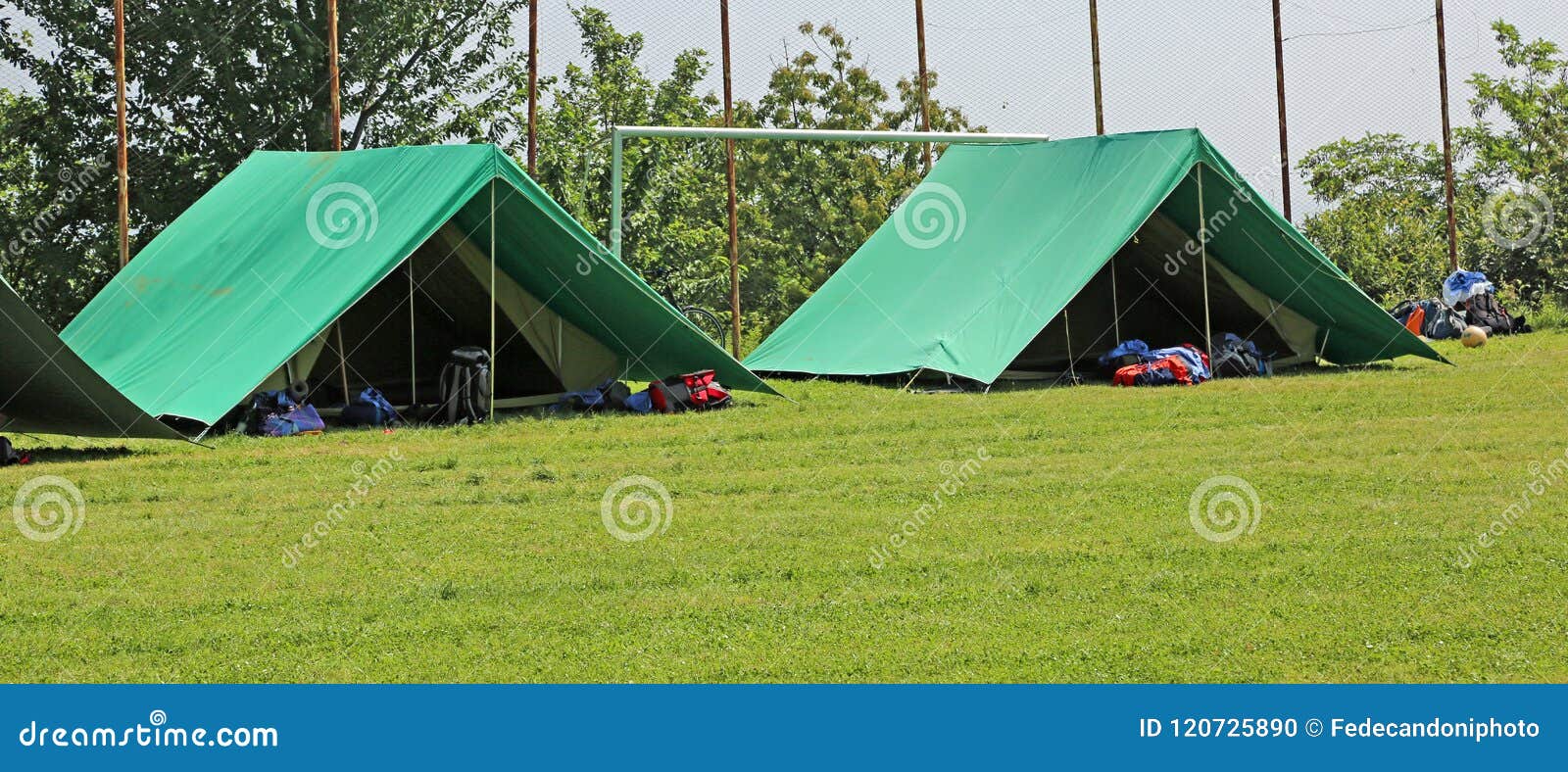 two green tents mounted in a meadow by the scouts