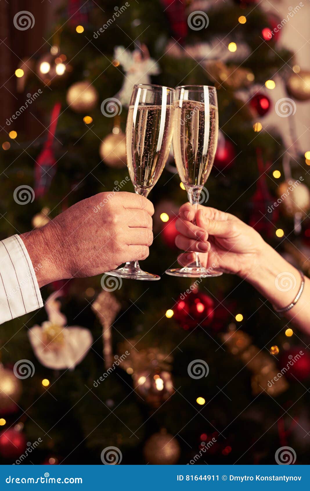 Two Hands Clinking Champagne Glasses Over Blurred New Year Background