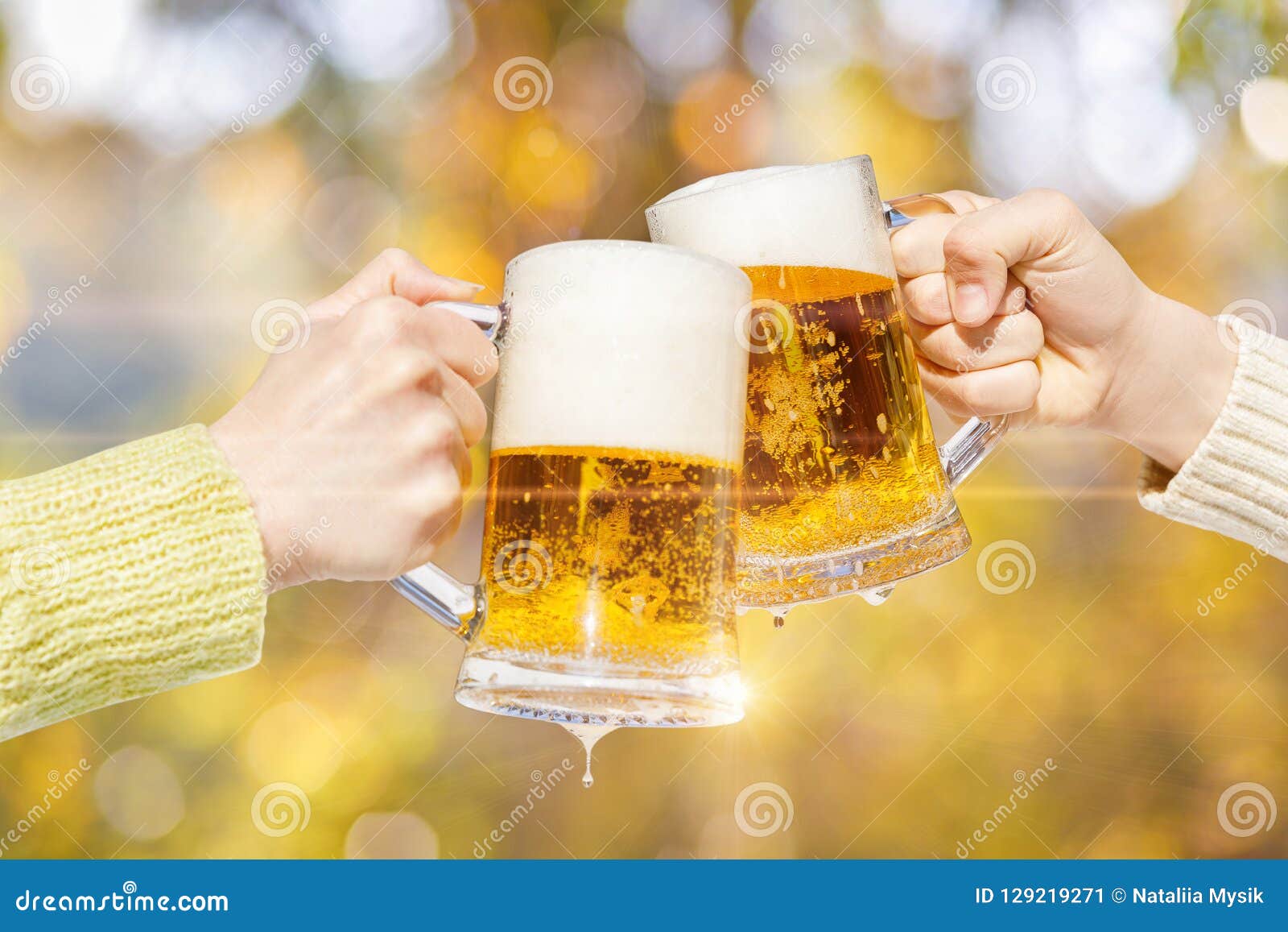 Two Hands are Clinking Mugs with Fresh Foam Beer . Stock Image Image