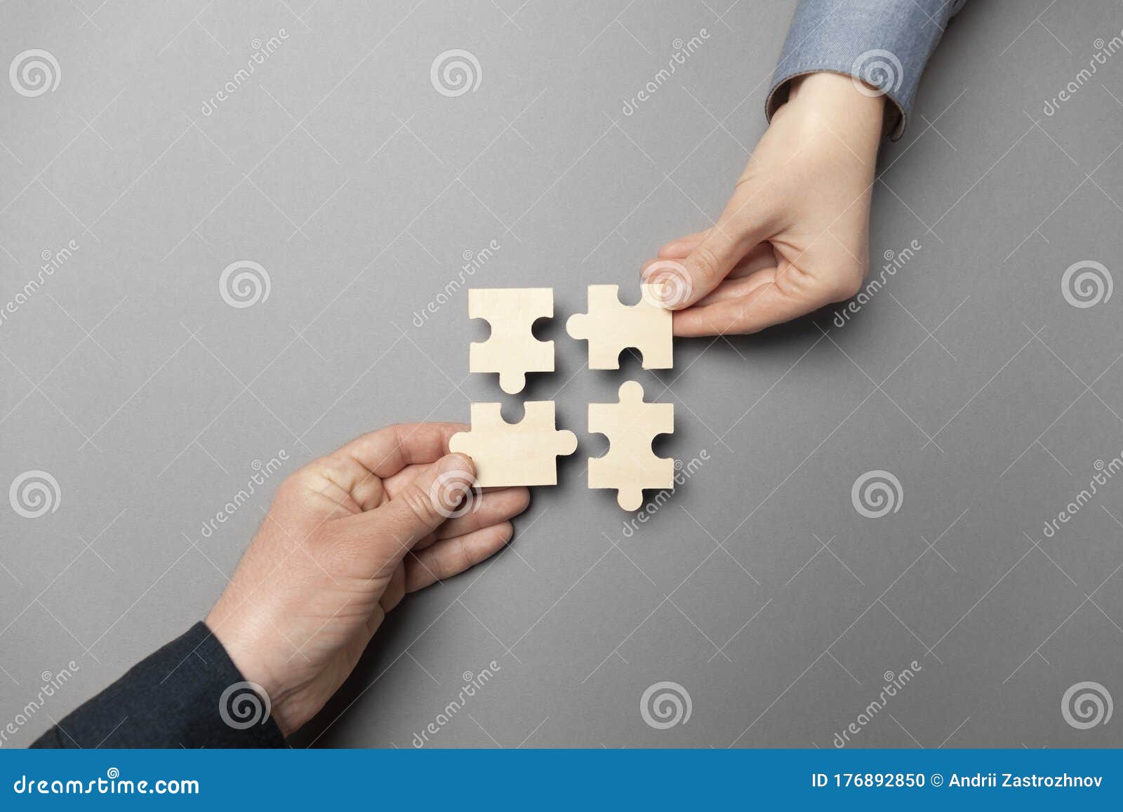 two hands connect puzzles on a grey background. cooperation and teamwork in business. collaboration people for success