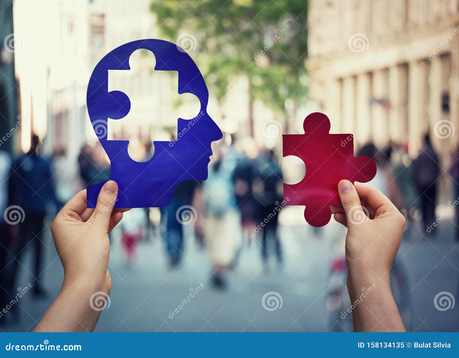 two hands holding a paper with human head and a puzzle piece. finding a cure to heal the disease. mental health concept, memory