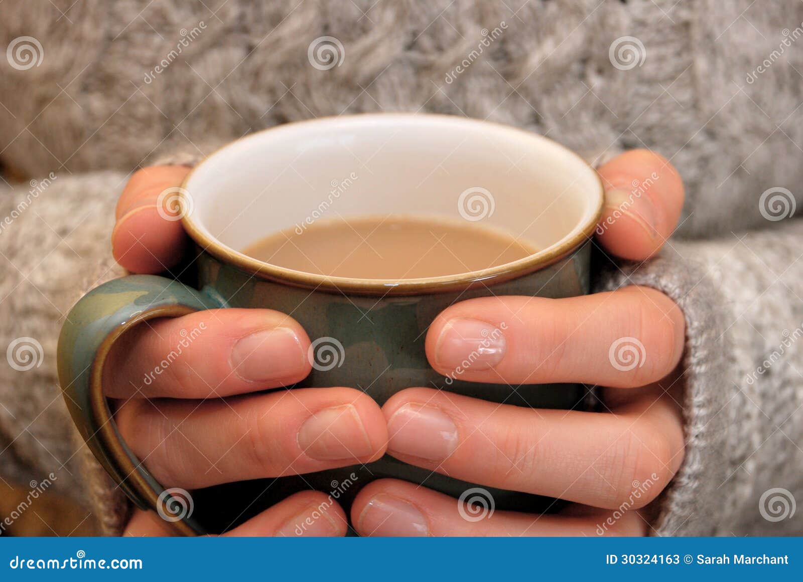 two hands keeping warm, holding a hot cup of tea or coffee