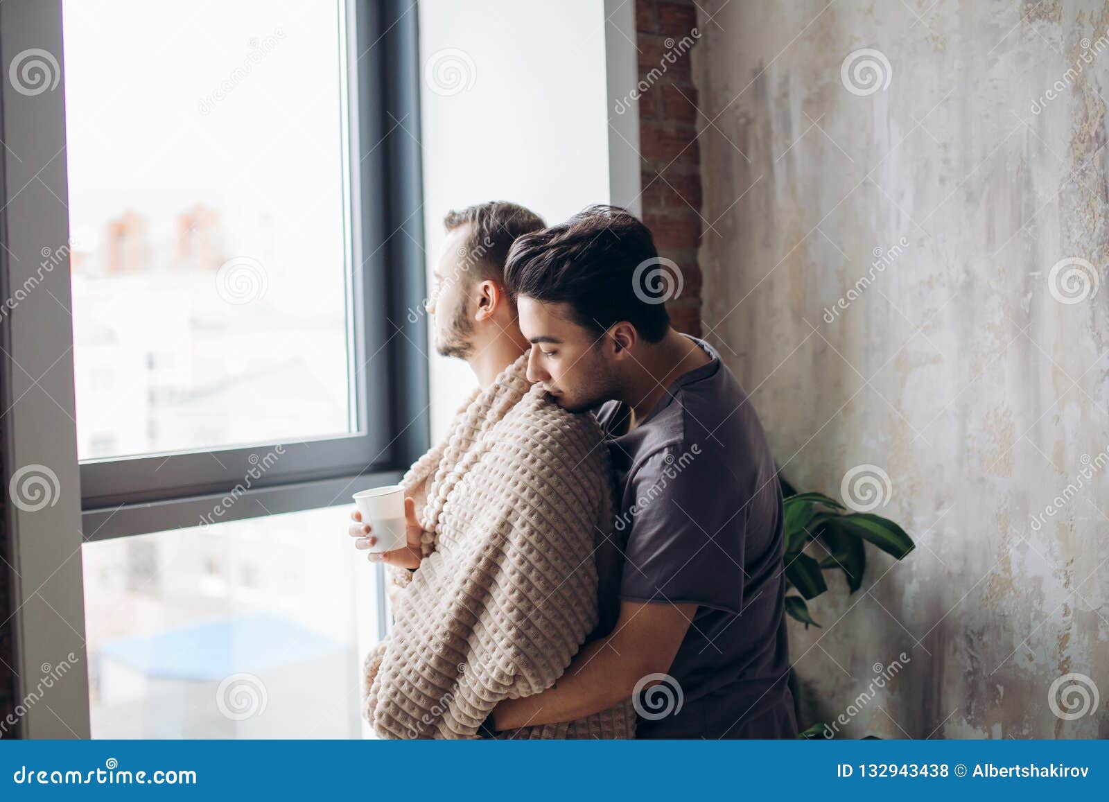 Two Handsome Homosexual Guys While Standing Near Window Stoc