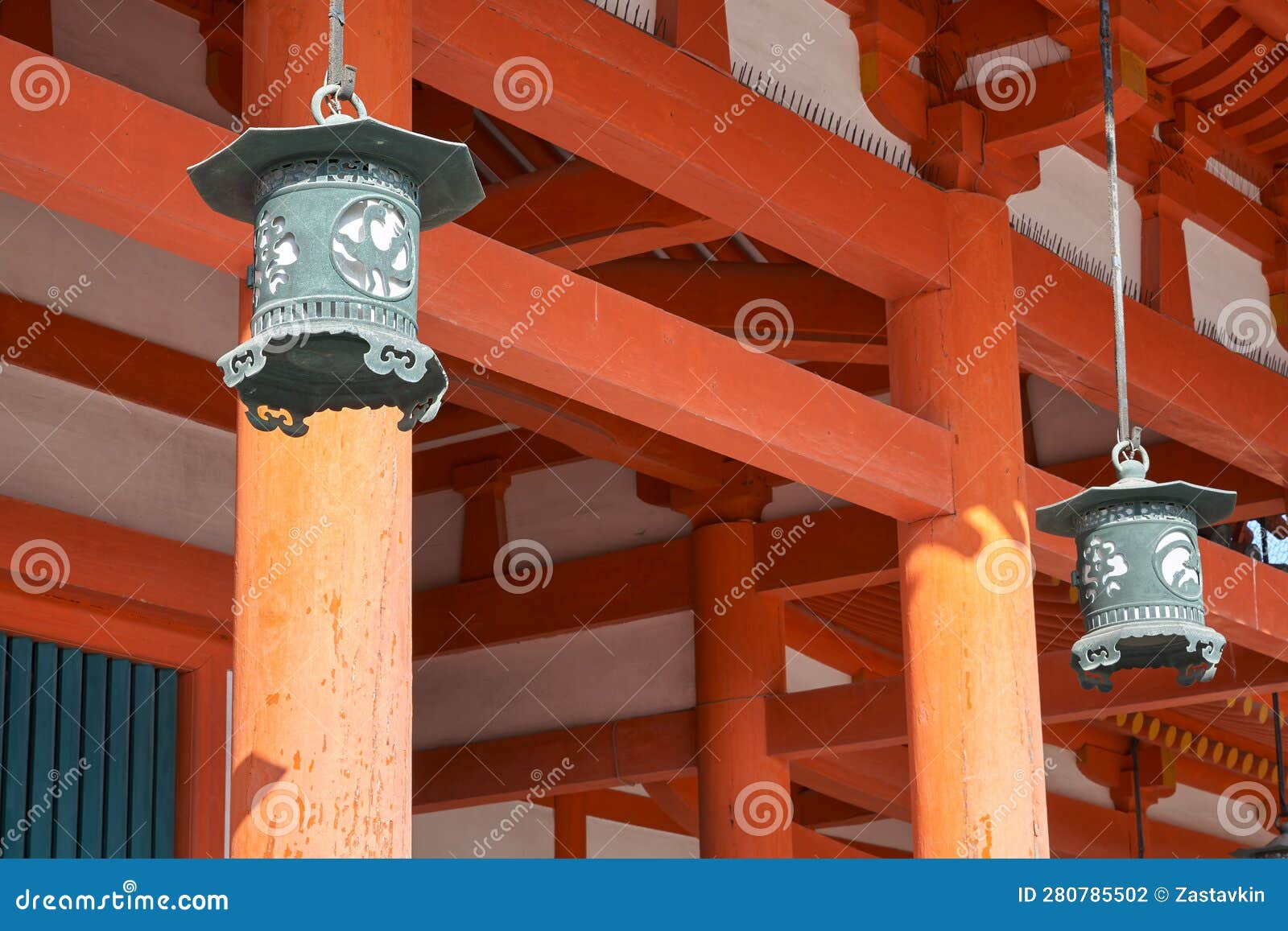 hanging copper lanterns on the background of vermilion columns. heian-jingu shrine. kyoto. japan